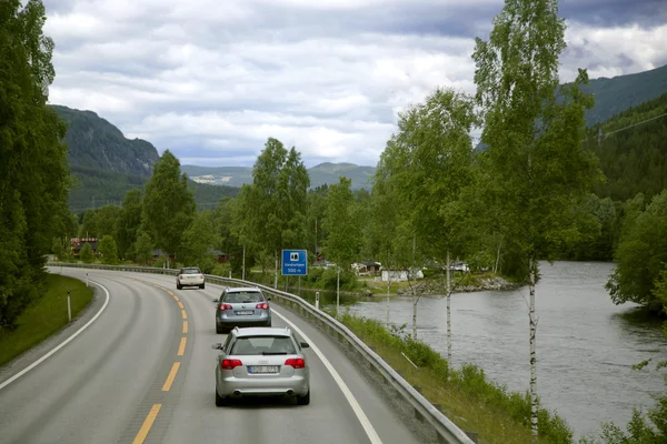 Auto going on a road winding between mountains — Stock Photo, Image