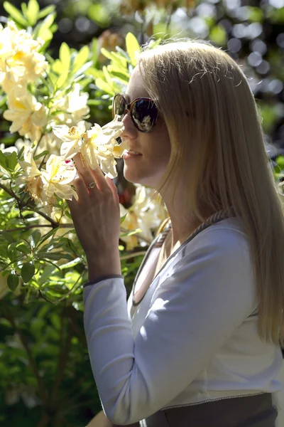 Chica atractiva cerca de la floración rododendro — Foto de Stock