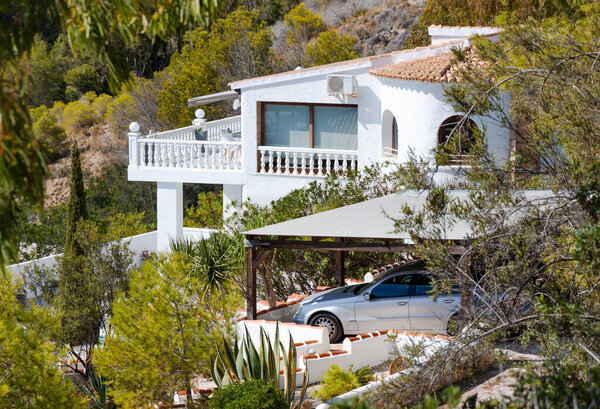 Терраса строительство домов с красной черепицей крыши балконы и веранды на горных склонах Хавеи, с озеленением кипарисов и цветущих кустарников, Испания