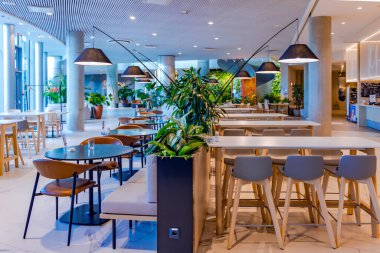 LATVIA, RIGA, OCTOBER, 20, 2025: Riga, Letonya 'da uzun saplı lambalar ve yeşil vahalarla dolu modern, rahat bir kafe..