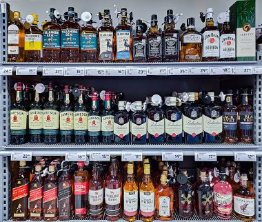 LATVIA, RIGA, OCTOBER, 29, 2025: Süpermarketteki raflarda viski ve brendi bulunan büyük bir alkolik sayacı. Riga. Letonya