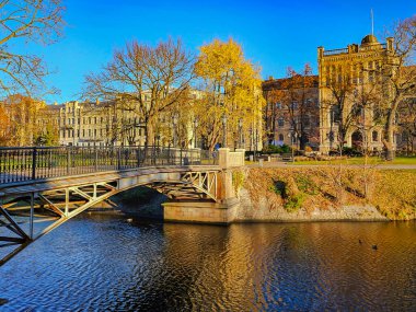 LATVIA, RIGA, NOVEMBER, 25, 2025: Riga Kanalı üzerindeki demir açılış köprüsü sabahın erken saatlerinde Letonya 'nın Riga kentsel mimarisinin arka planına karşı