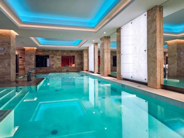LATVIA, RIGA, NOVEMBER, 25, 2025: Aynalı mermer bir salonda sıcak maden suyu olan bir havuz ve Riga, Letonya 'daki 5 yıldızlı Grand Kempinski Hotel' de sauna kompleksi.