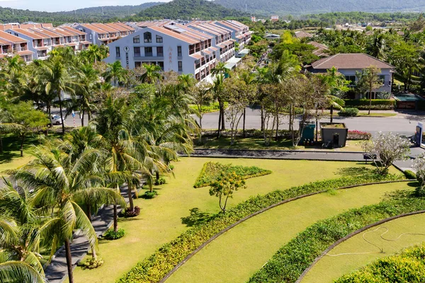 Vietnam, Phu Quoc, 5 Ocak 2026: Vietnam 'ın Phu Quoc kentindeki Novotel' in bahçesinde çiçek açan çalılar ve uzun palmiye ağaçları ile manikürlü çimenler
