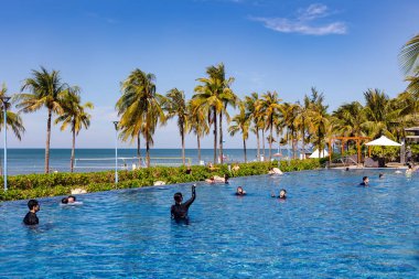 Vietnam, Phu Quoc, 5 Ocak 2026: Tatilcilerle birlikte Phu Quoc Adası, Vietnam 'daki Tayland Körfezi' nin arka planına karşı Novotel otelinde deniz suyu yüzme havuzu manzarası