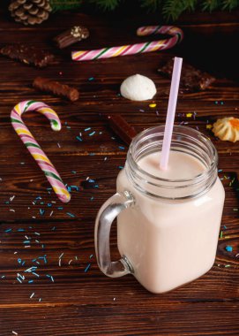 Sütlü, tarçınlı, şekerli ve saman tüplü bir bardak sıcak kakao.