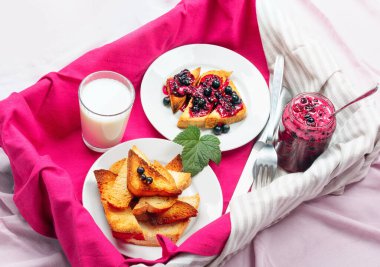 Lezzetli tost ekmeği ev yapımı frenk üzümü reçeli ve süt parlak kırmızı masa aralığında.