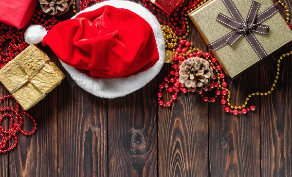 Geschenkschachteln Mit Perlen Spielzeug Und Nikolausmütze Auf Einem Holztisch Weihnachten — Stockfoto
