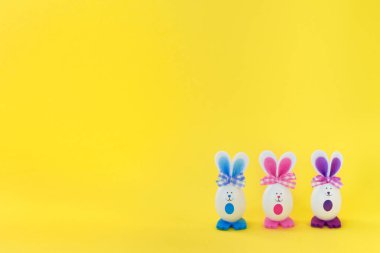 Parlak sarı arka planda komik Paskalya tavşanları. Mutlu Paskalyalar.
