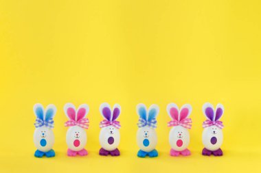 Parlak sarı arka planda komik Paskalya tavşanları. Mutlu Paskalyalar.