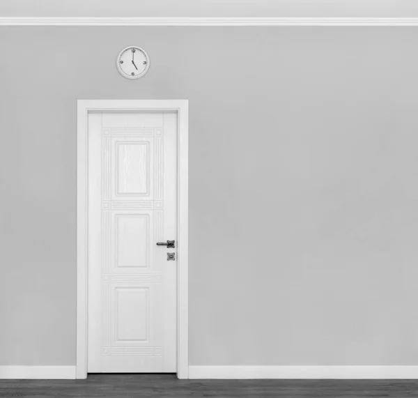Grey wall with white door and clock. Traditional afternoon tea  symbols of England. Concept or creative idea that means tea time. Five tea concept.