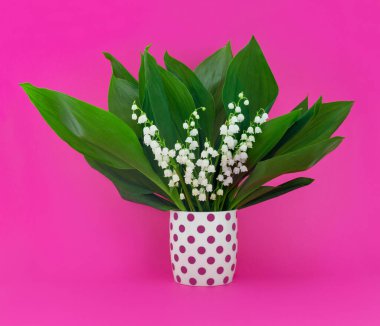 Anneler günü için tebrik kartı. Üzerinde pembe arka planda bir buket nilüfer çiçeği var. Bahar doğası kavramı.