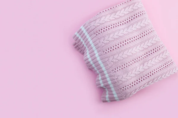 Woolen knitted pink sweater on paper background. Flatlay Topview with copy space for your text