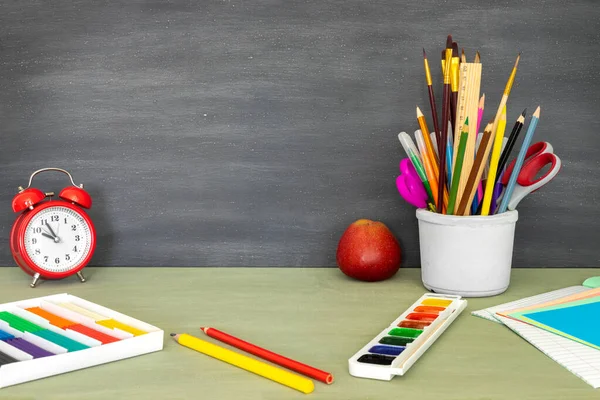 Mesaj için yer olan okula geri dön. Web tasarımı için yatay pankart. Okul malzemelerinin parlak bir şekilde toplanması. Çalışma için masaüstünde kalemler, boyalar, plastikler, çalar saat ve elma var..