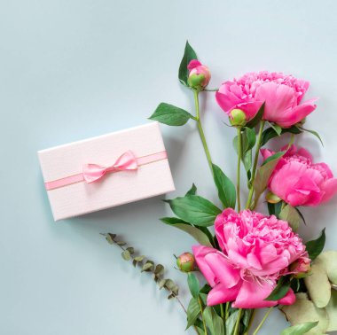 Bir buket güzel pembe şakayık ve hediye paketleri. Tebrikler ya da davetiyeler için pankart.