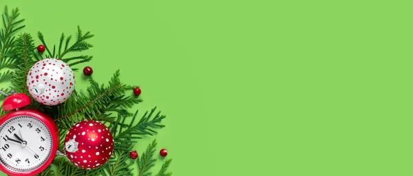 緑の紙の背景に赤と白のクリスマスボール 目覚まし時計や木の枝 新年の５分前 — ストック写真