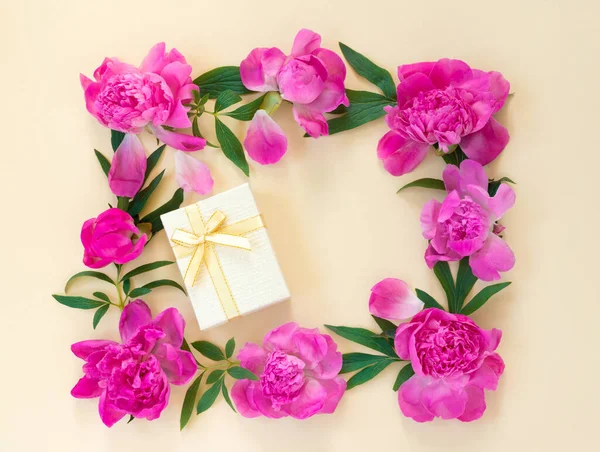 一束漂亮的粉红牡丹和礼品盒在黄色背景的包装纸上 假期的贺卡 具有文本复制空间的创造性背景 — 图库照片