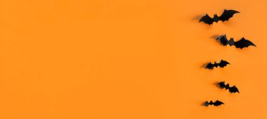 Turuncu arka planda siyah yarasalar olan Cadılar Bayramı kartı. Tebrikler ya da davetiyeler için pankart.