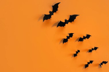 Turuncu arka planda siyah yarasalar olan Cadılar Bayramı kartı. Tebrikler ya da davetiyeler için pankart.