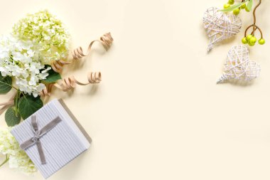 Bej arka planda hediye kutusu olan güzel ortanca buketi. Kalpli tebrik kartı. Metin için kopyalama alanı olan yaratıcı arkaplan.