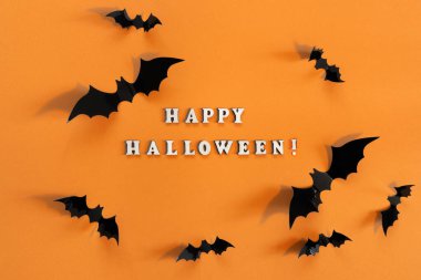 Turuncu arka planda siyah yarasalar olan Cadılar Bayramı kartı. Tebrikler ya da davetiyeler için pankart.