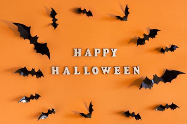 Turuncu arka planda siyah yarasalar olan Cadılar Bayramı kartı. Tebrikler ya da davetiyeler için pankart.