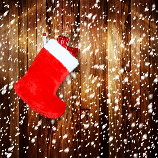 Bota de Natal vermelho com presentes na parede de madeira de fundo — Fotografia de Stock