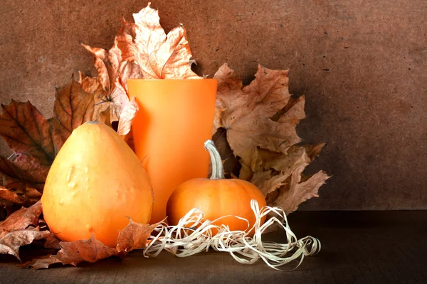 Haufen von Kürbissen mit Herbstlaub auf abstraktem Hintergrund — Stockfoto