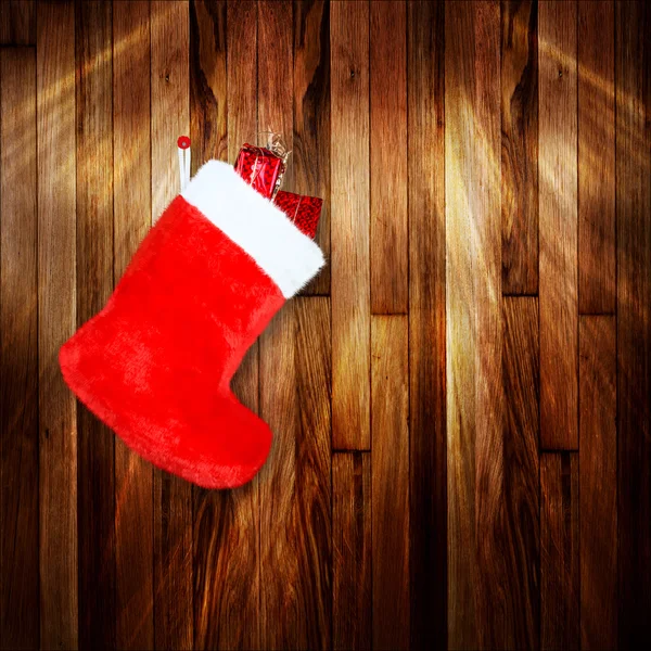 Röd jul boot med gåvor på bakgrund trä vägg — Stockfoto