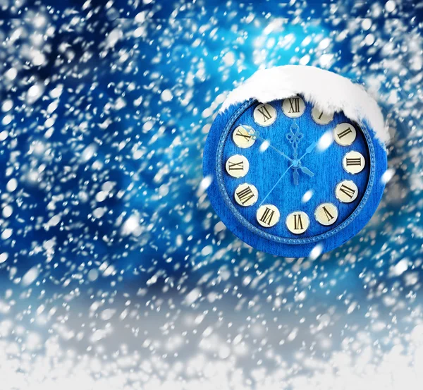 Snow-covered clock on abstract blue background — Stock Photo, Image