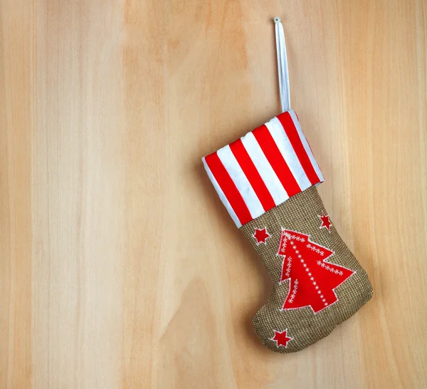 赤いクリスマスのブーツともにギフトの背景木製の壁 — ストック写真