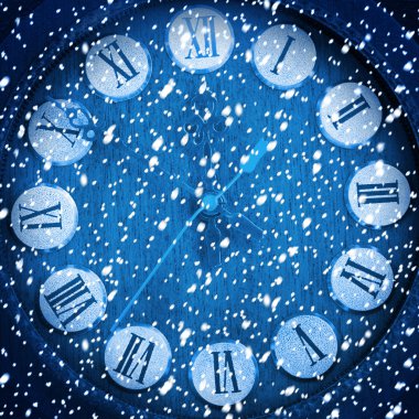 Snow-covered clock on abstract blue background  clipart