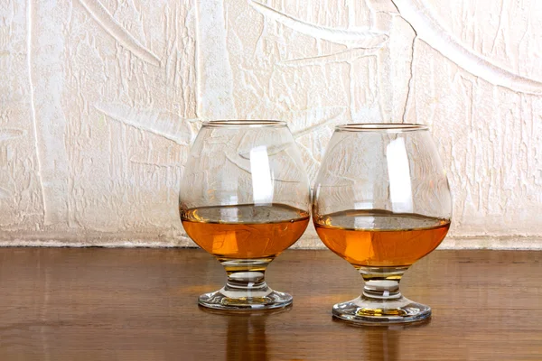 Two goblets of brandy on wooden old counter top — Stock Photo, Image