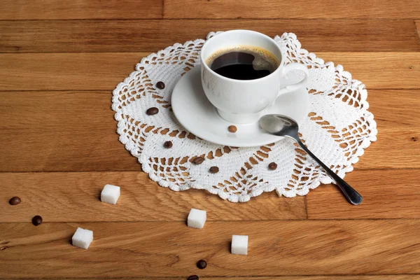 Hot fresh coffee in a white cup with sugar on wooden table — Stock Photo, Image