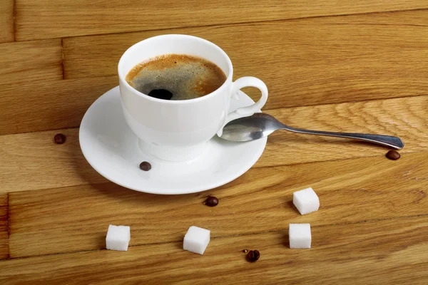Café fresco caliente en una taza blanca con azúcar en la mesa de madera —  Fotos de Stock