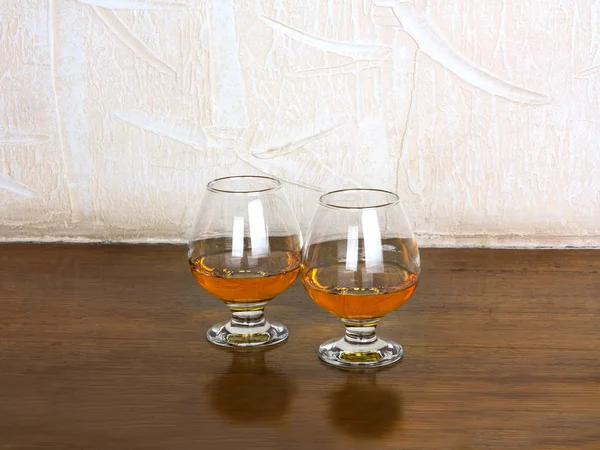 Two goblets of brandy on wooden old counter top — Stock Photo, Image