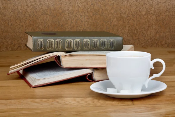 Taza caliente de café fresco en la mesa de madera y una pila de libros — Foto de Stock