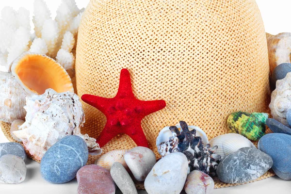 Pretty straw hat with starfish, pebble and  mussel — Stock Photo, Image