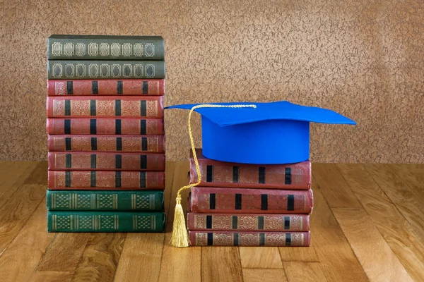 Afstuderen mortarboard boven op de stapel boeken — Stockfoto