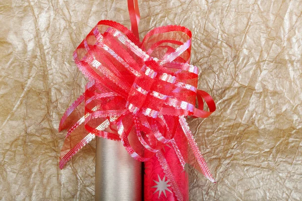 Rolls of multicolored wrapping paper with red bow for gifts on g — Stock Photo, Image