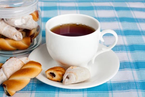 Fresh delicious cookies and hot tea on tablecloth — Stock Photo, Image