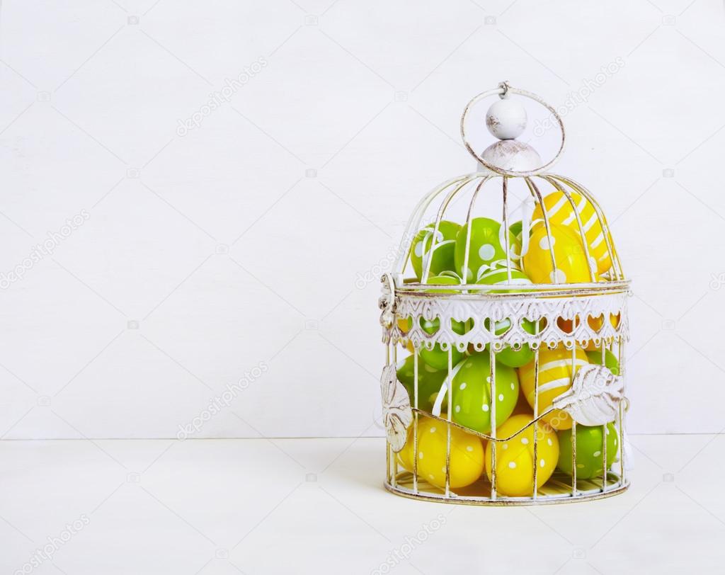Decorative pastel Easter eggs in vintage cage 