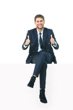 Beyaz bir üstünde otururken yakışıklı genç iş adamı