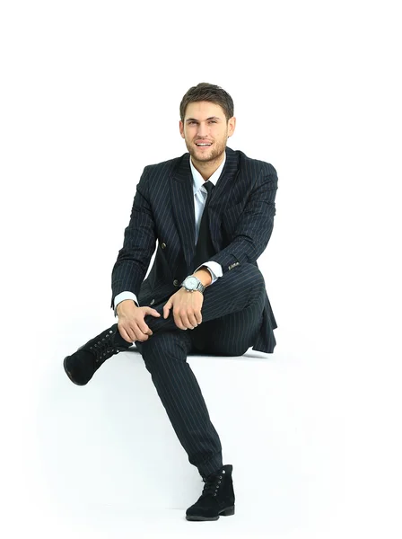 Handsome young business man sitting on a white modern chair — Stock Photo, Image