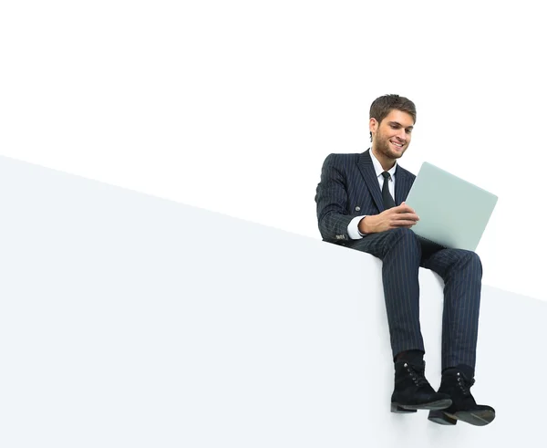 Handsome young business man sitting on a white top — Stock Photo, Image