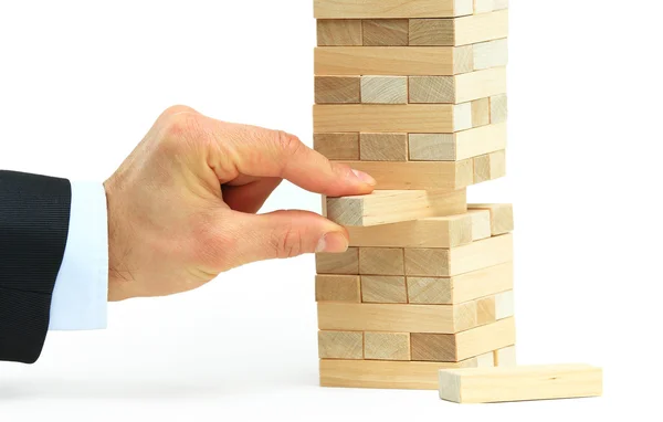 La torre de los bloques de madera y la mano del hombre toman un bloque —  Fotos de Stock