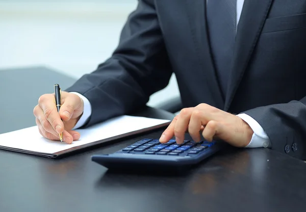 Homem de negócios usando calculadora no escritório — Fotografia de Stock