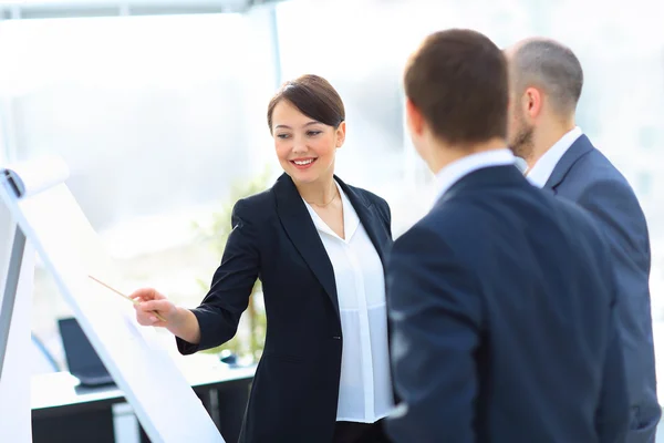 Porträt einer Geschäftsfrau, die seine Idee seinen Kollegen bei einem Meeting vorstellt. — Stockfoto