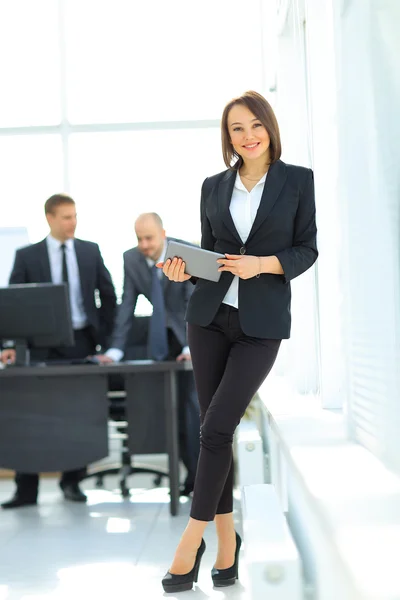 Heureuse jeune femme en utilisant tablette numérique au bureau — Photo