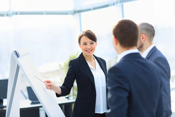 Porträt einer Geschäftsfrau, die seine Idee seinen Kollegen bei einem Meeting vorstellt. — Stockfoto